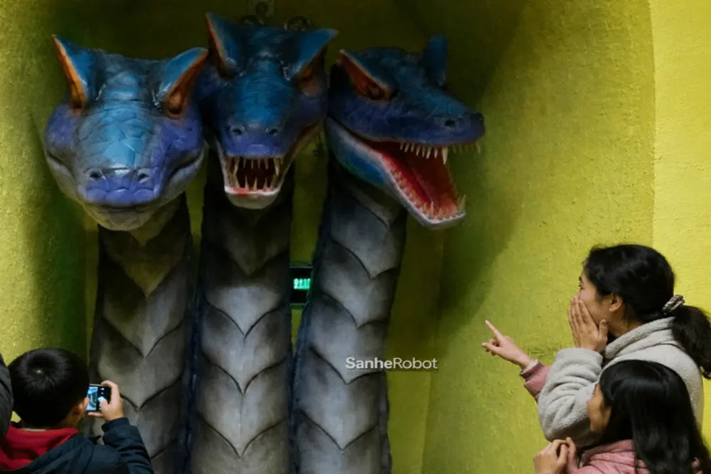 Family visitors interacting with three-head animatronic dragon in cave attraction