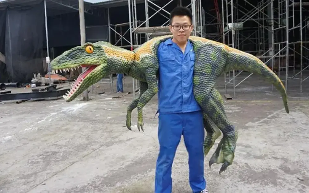 large shoulder dinosaur puppets operated by worker in factory demonstration