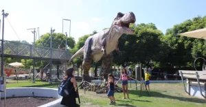 Animatronic dinosaurs theme park scene featuring a T. rex and visitors