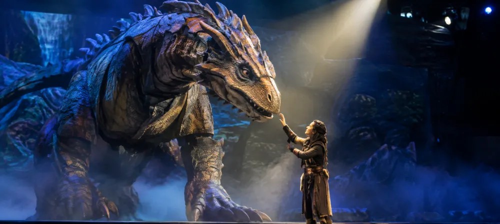 Large animatronic character performing with a live actor in a live entertainment production.